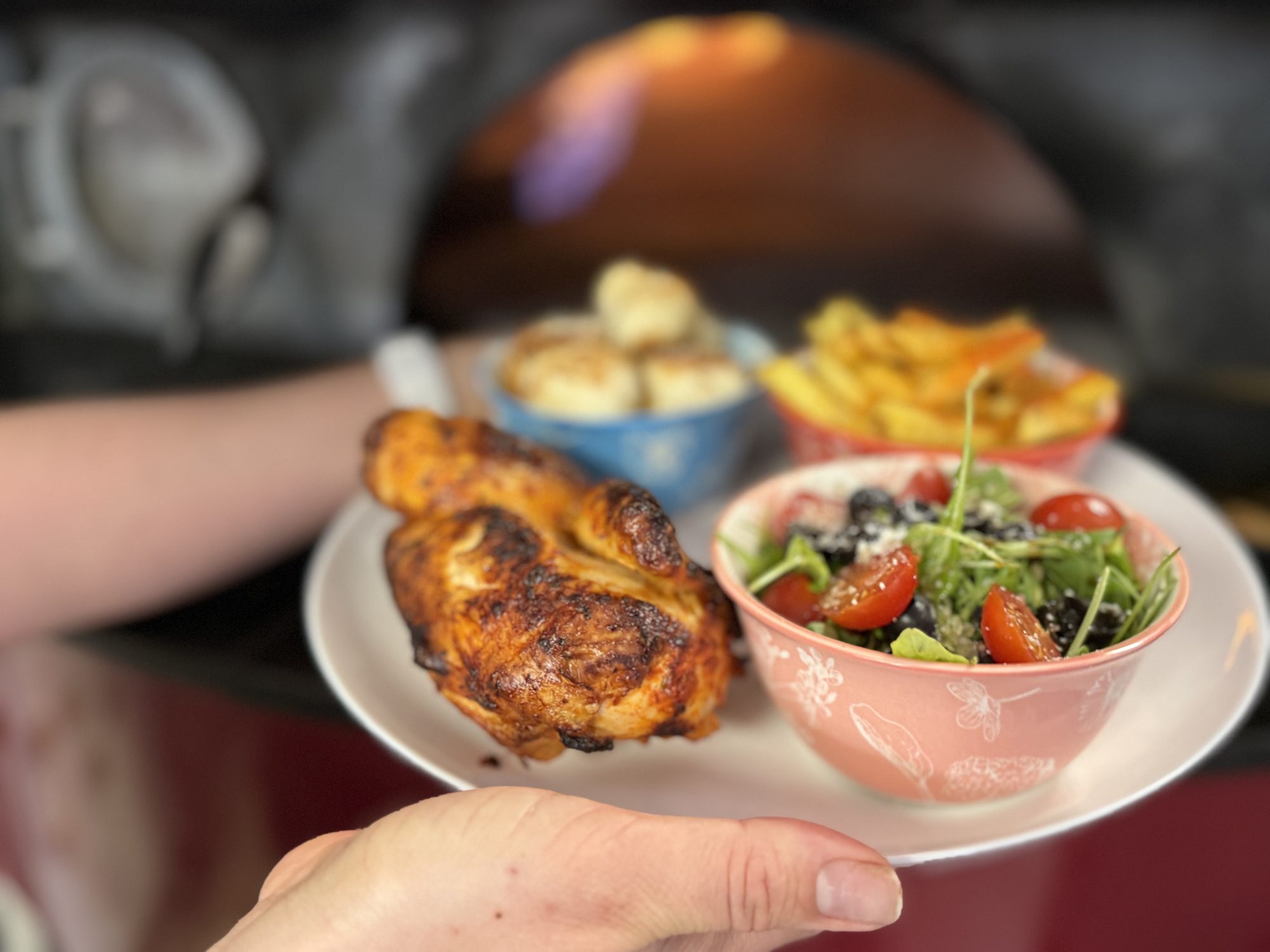 Wood-fired half chicken with arugula salad, hand-cut fries and dough balls served in front of our wood-fired oven